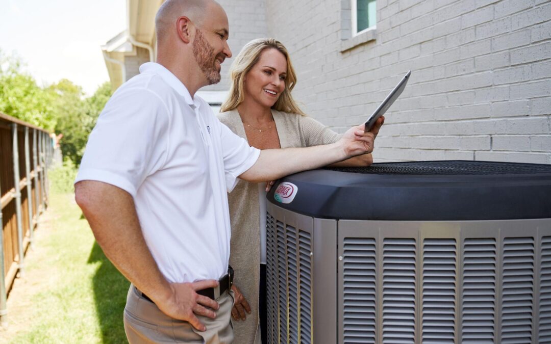 A happy couple reading energy-saving tips for their HVAC system